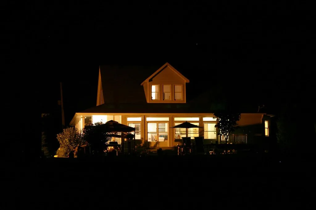 Home glowing at night with lit porch and windows
