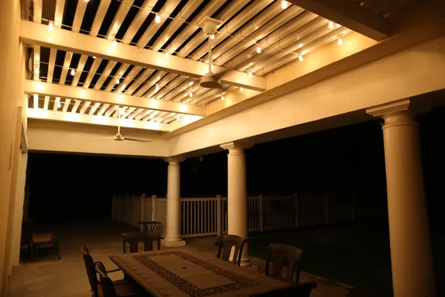 Covered patio and pergola with warm downlights at night