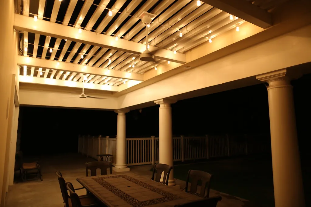 Covered patio and pergola with warm downlights at night