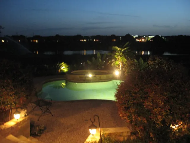 Pool and garden with path lights seen from above at dusk